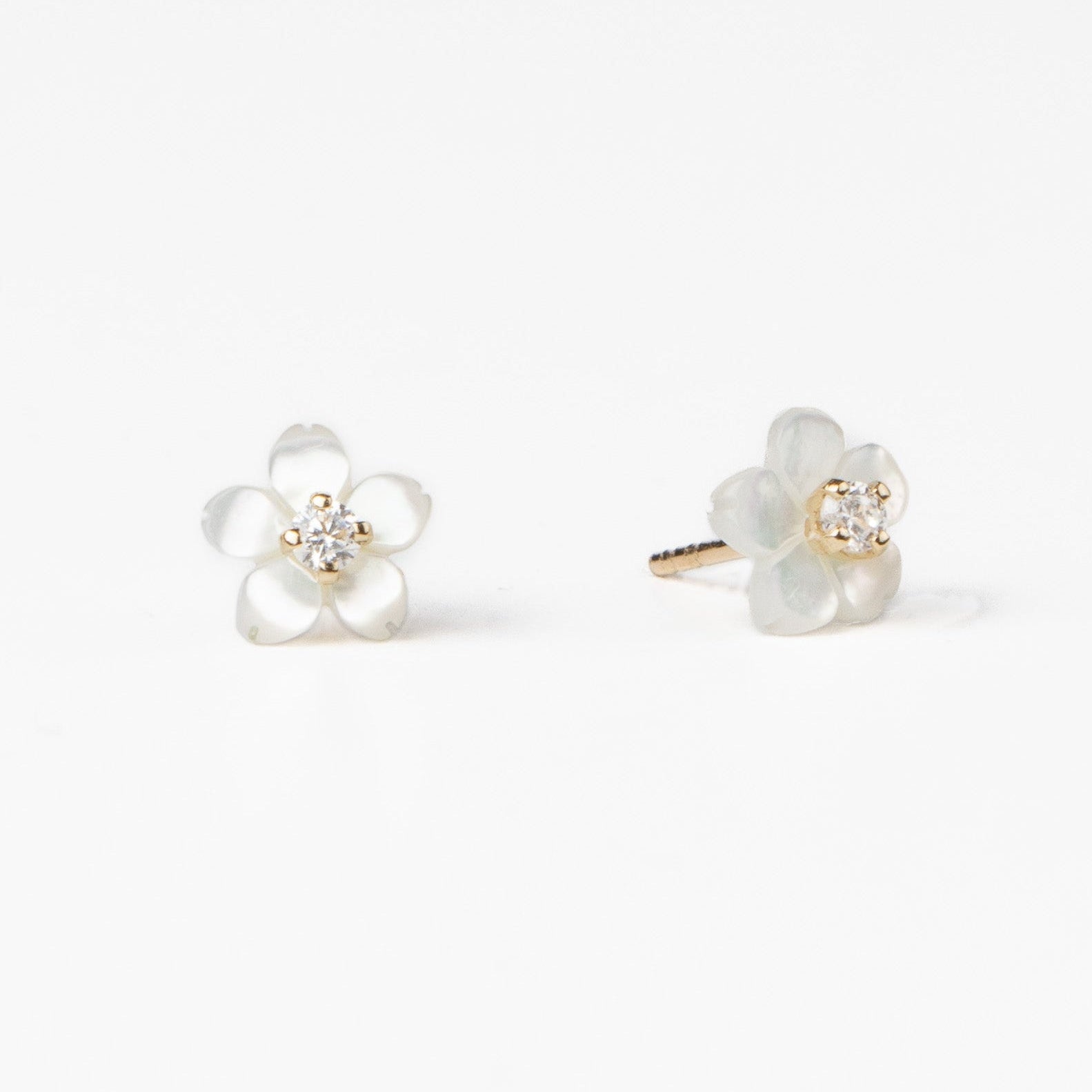 Cercei stud Sakura din aur solid 14K cu sidef natural în formă de floare de cireș și zirconiu, vedere frontală pe fundal alb.