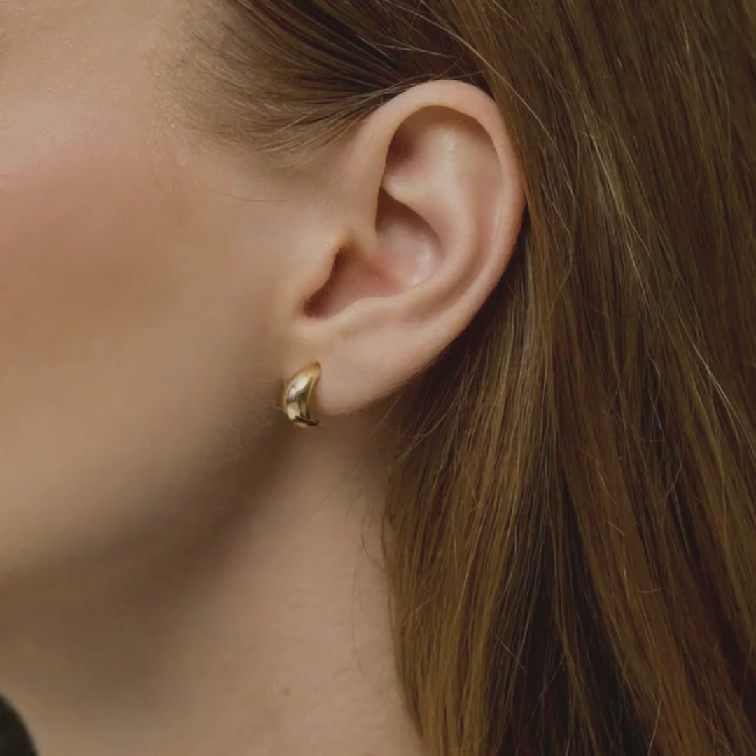 Model purtând cerceii Gold Drop din aur 14K, evidențiind modul în care designul fluid reflectă lumina pe lobul urechii.